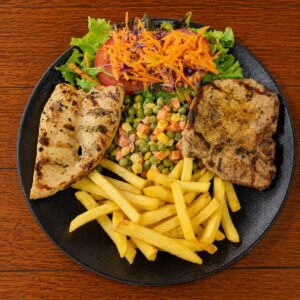 Pollo Chuleta papas fritas y ensalada